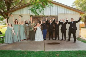 Wedding party members line up in various fun poses against rustic barn walls for creative outdoor photo sequence.