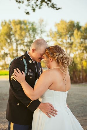 Intimate wedding moment between couple in formal attire embracing on an autumn afternoon.