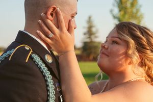 Close-up tender moment between newlyweds during outdoor sunset photo session.
