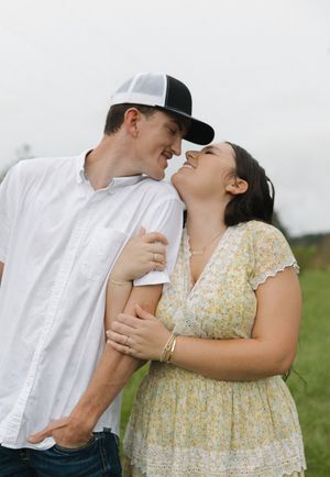 Tender moment between couple in outdoor setting with natural scenery.