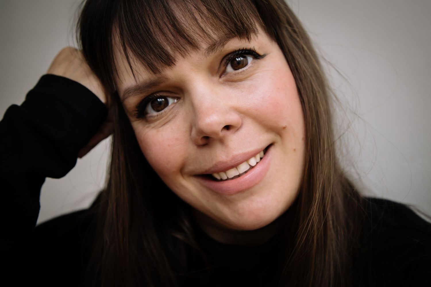 A series of candid portrait shots showing expressions of joy and playfulness from different angles in warm lighting.