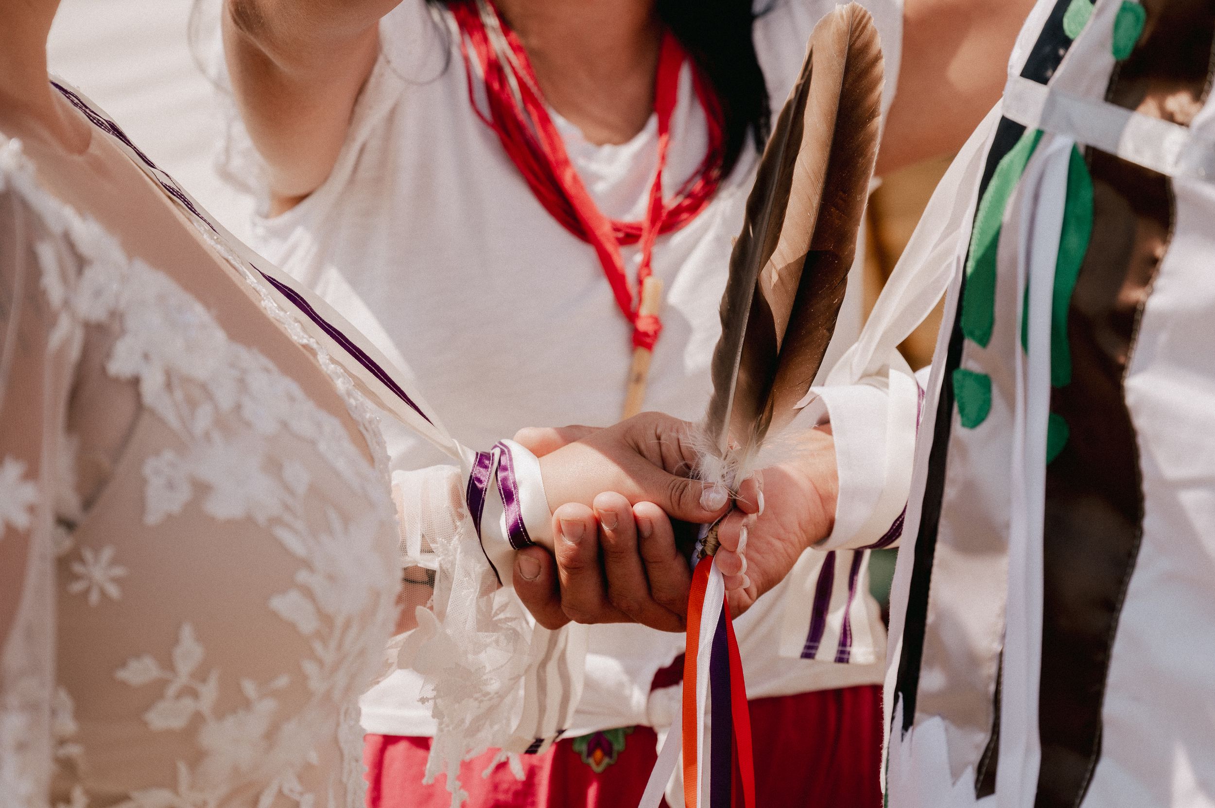 Healthcare worker in white attire handling medical equipment and tubes with red accents.