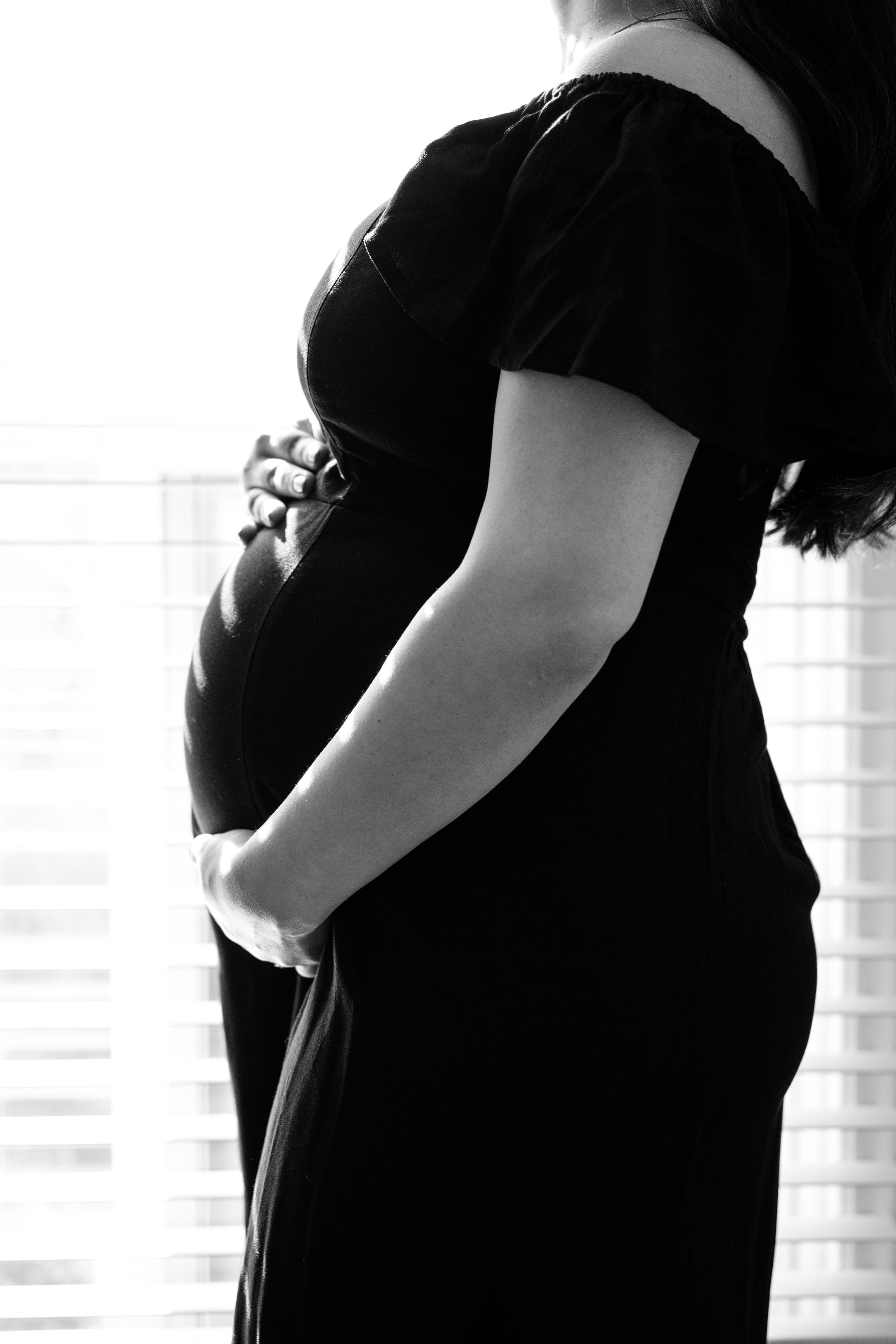 Black and white maternity photo with natural-light backlit lighting captured by maternity photographer Phoebe Lee Photo, based in Toronto.
