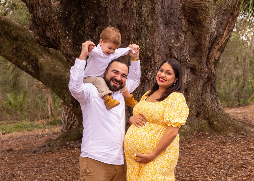 Happy family moment captured under a large oak tree.