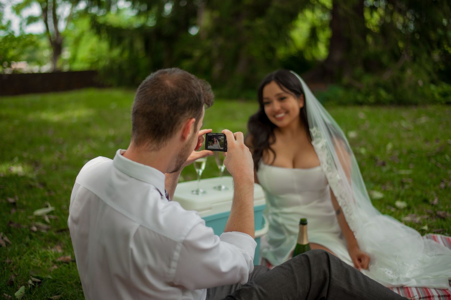 Groom, taking photo of bride on wedding day outdoors in Richmond, Virginia