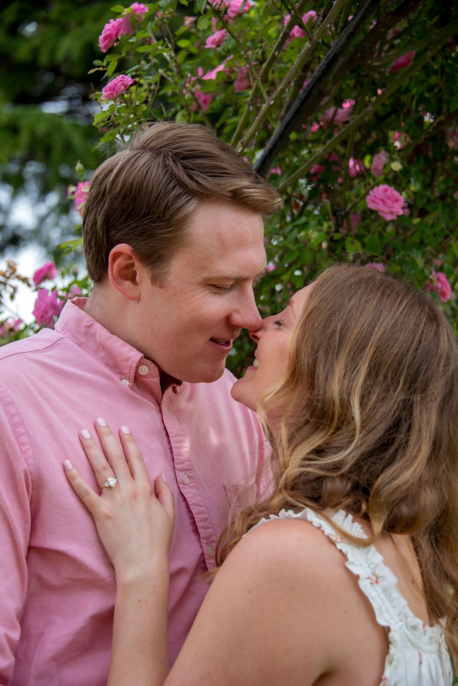 Young couple about to kiss with roses in background