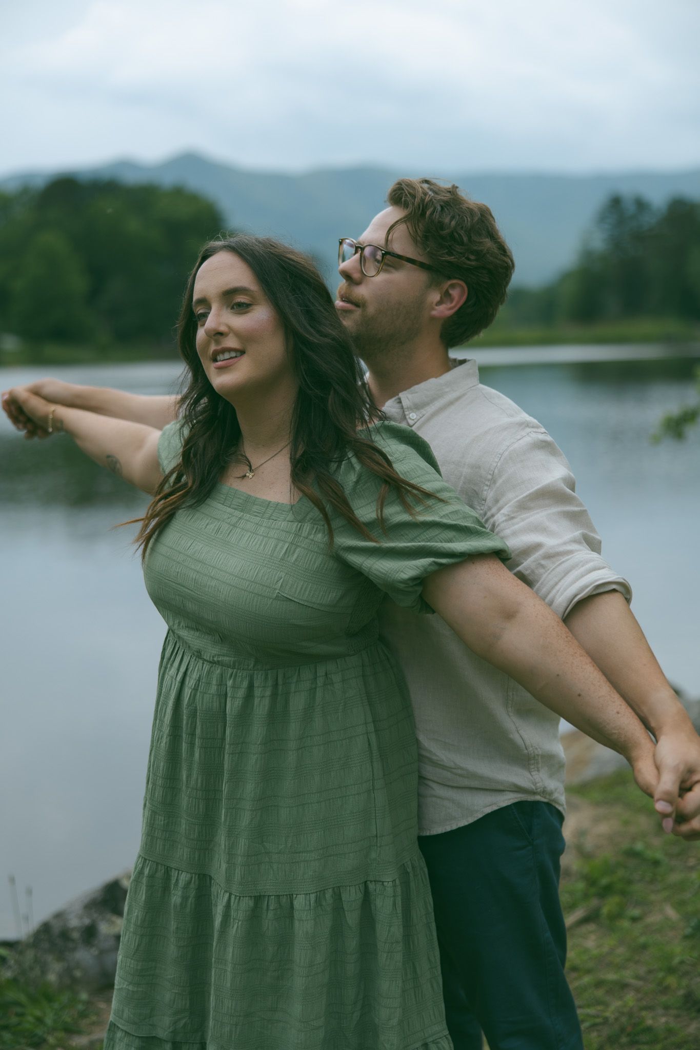 couple holding hands after romantic proposal at blue ridge mountain overlook near Asheville, North Carolina
