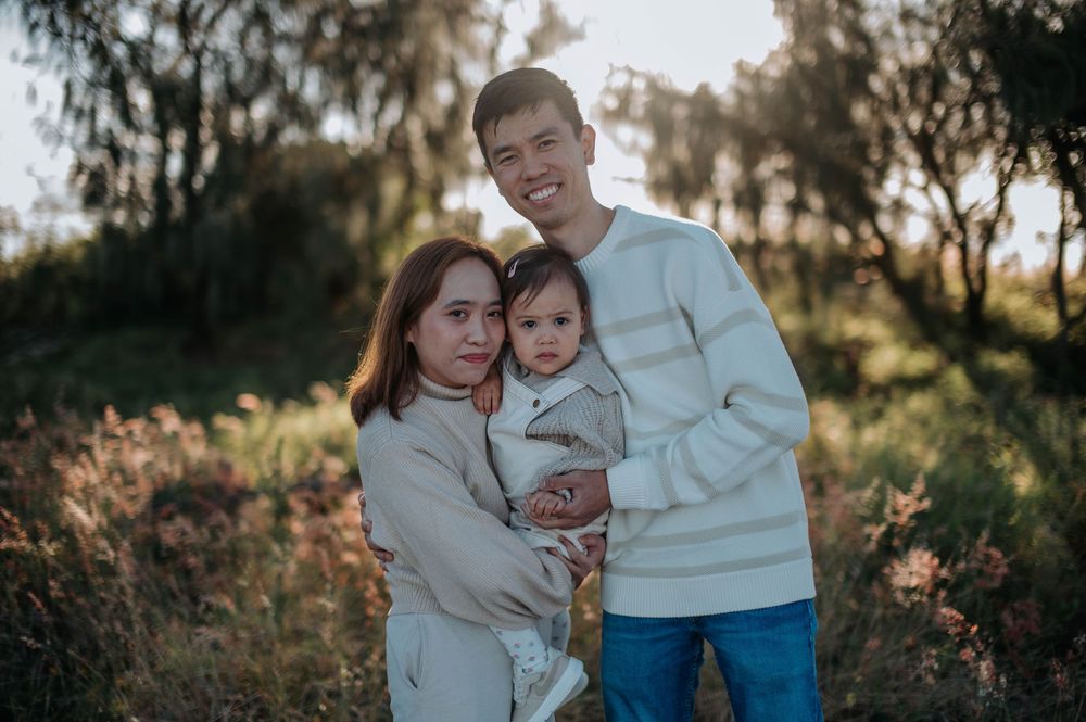 Family shares tender outdoor moments together during golden hour photoshoot in nature setting.