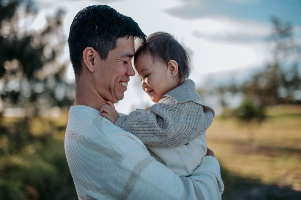 A touching moment between parent and child outdoors during golden hour in nature.