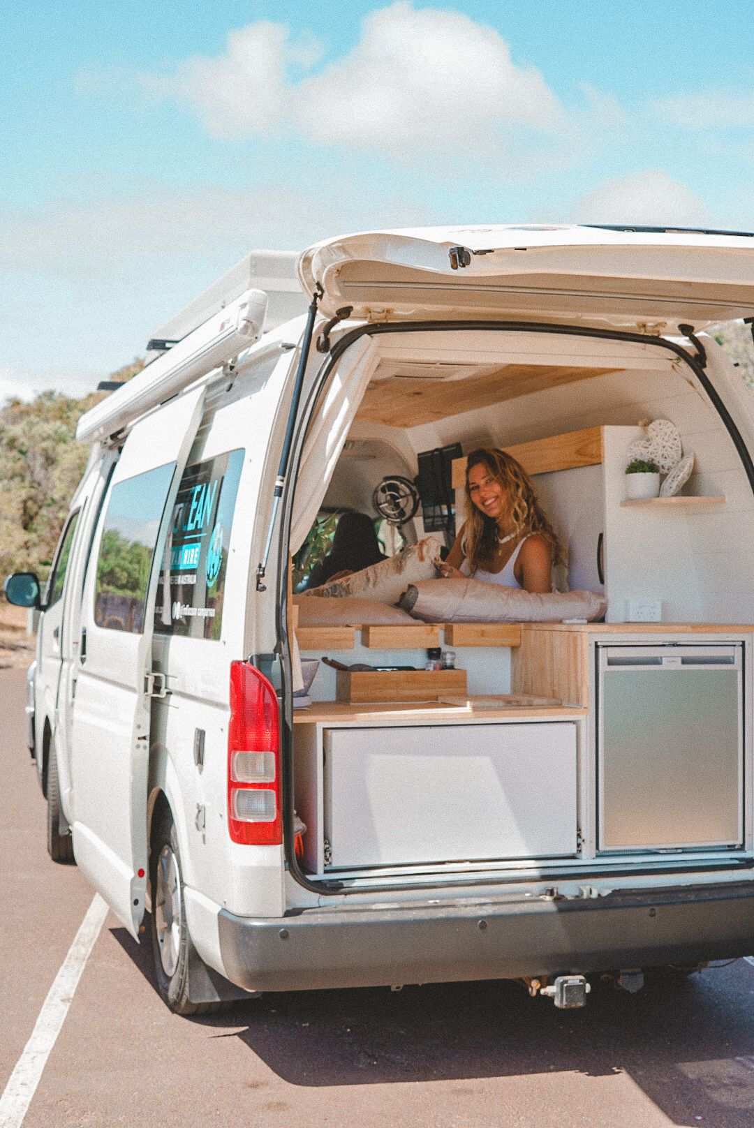Interior view of custom camper van conversion showing kitchen setup and storage solutions.