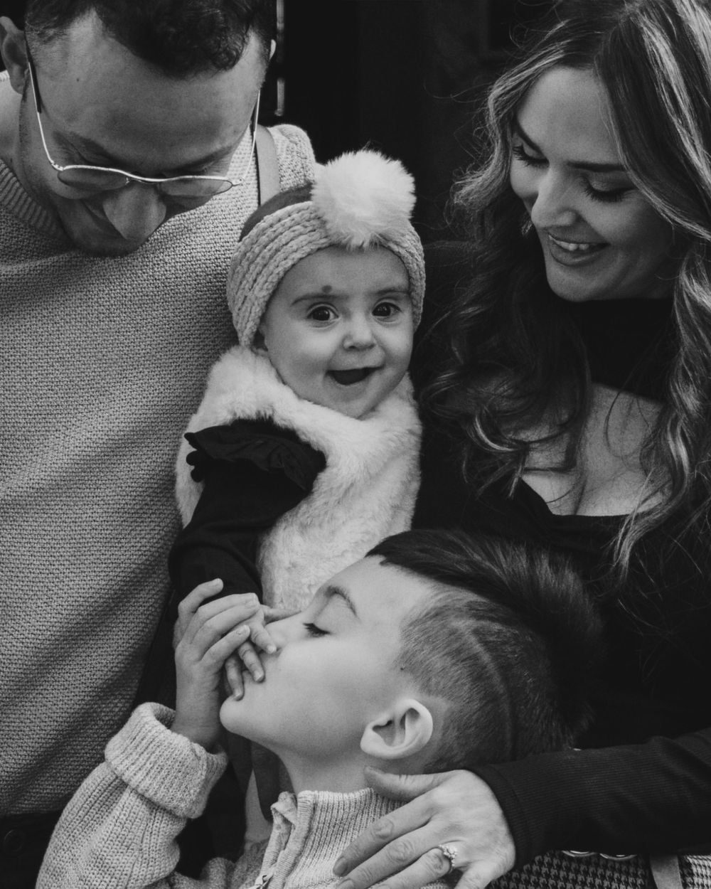 A candid black and white family moment capturing joy and laughter.