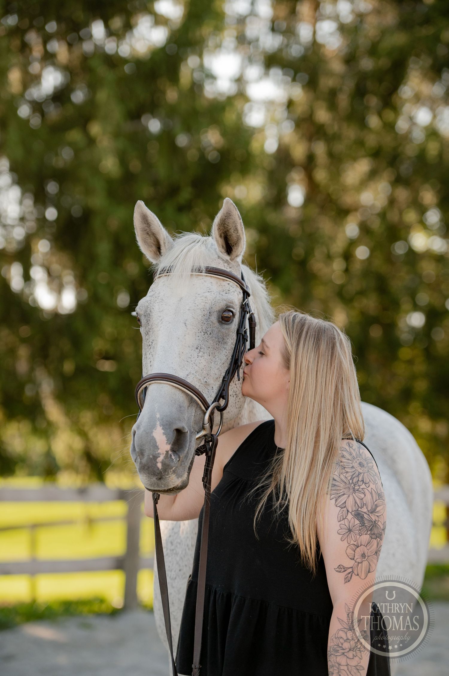 An intimate moment between a white horse and owner during an outdoor photoshoot.