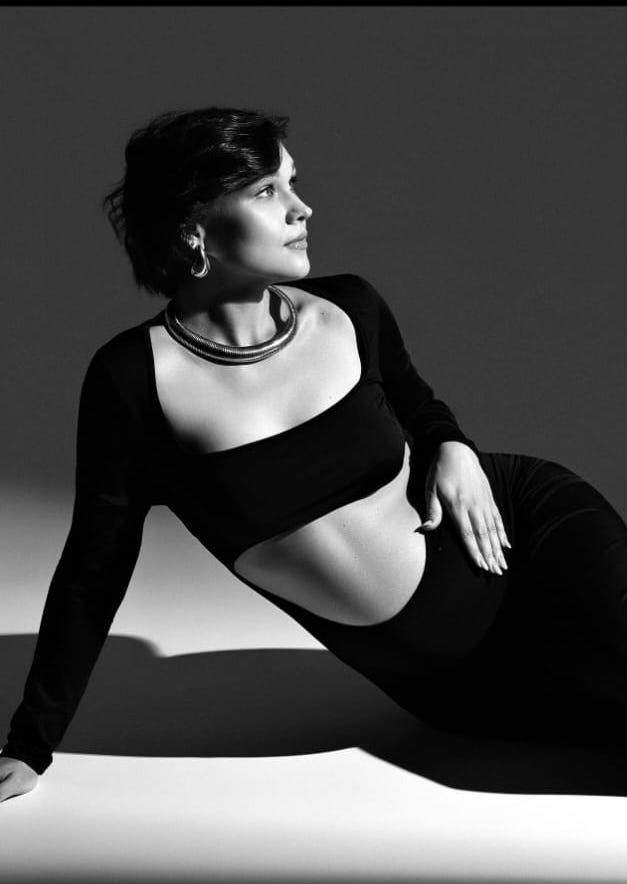 Artistic black and white maternity photo showing side pose in cut-out dress.