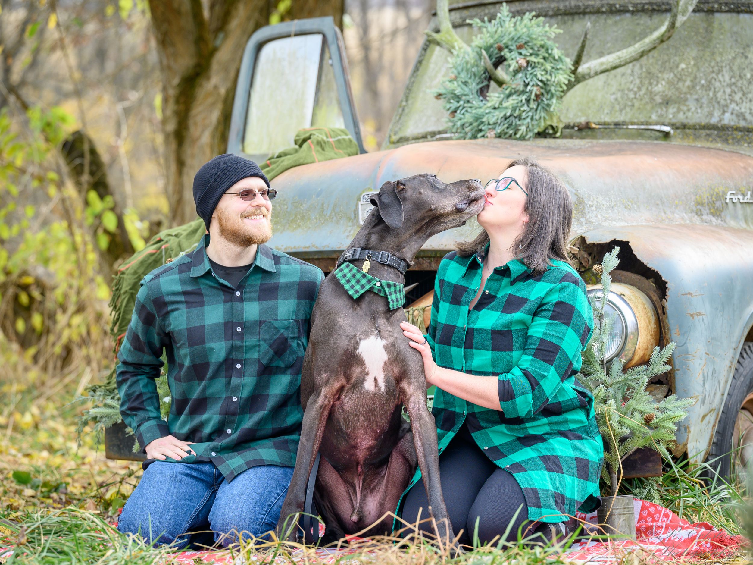 Portrait of a family with a dog in front of an old truck