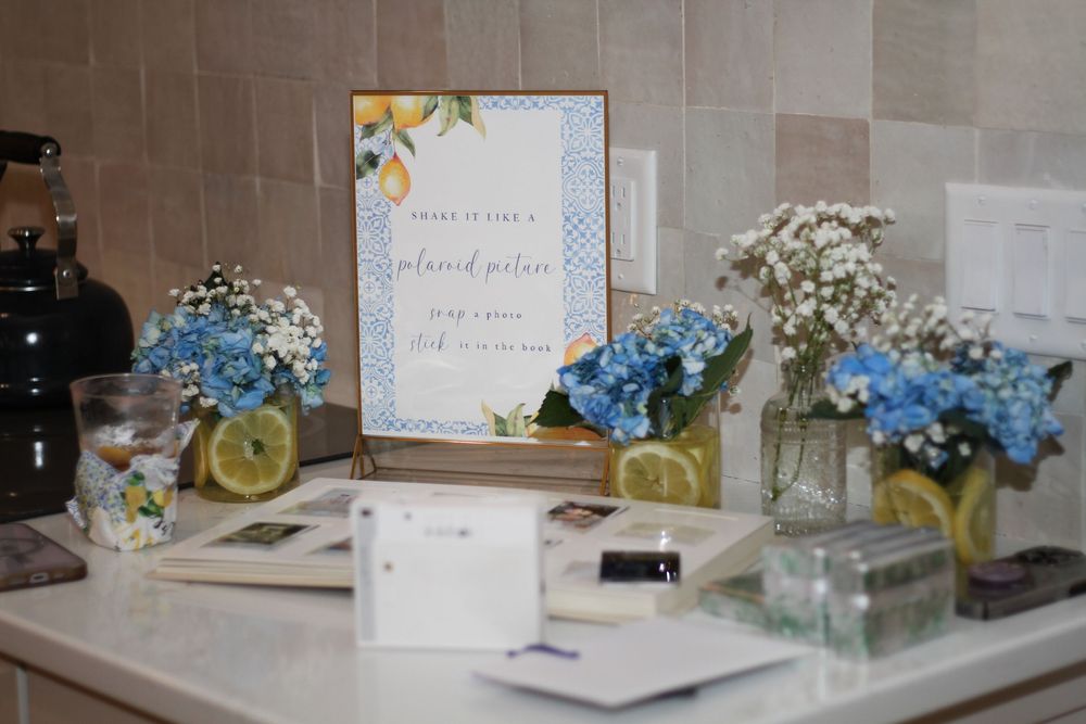 Wedding reception table setup with floral decorations, hydrangeas, and a framed sign.