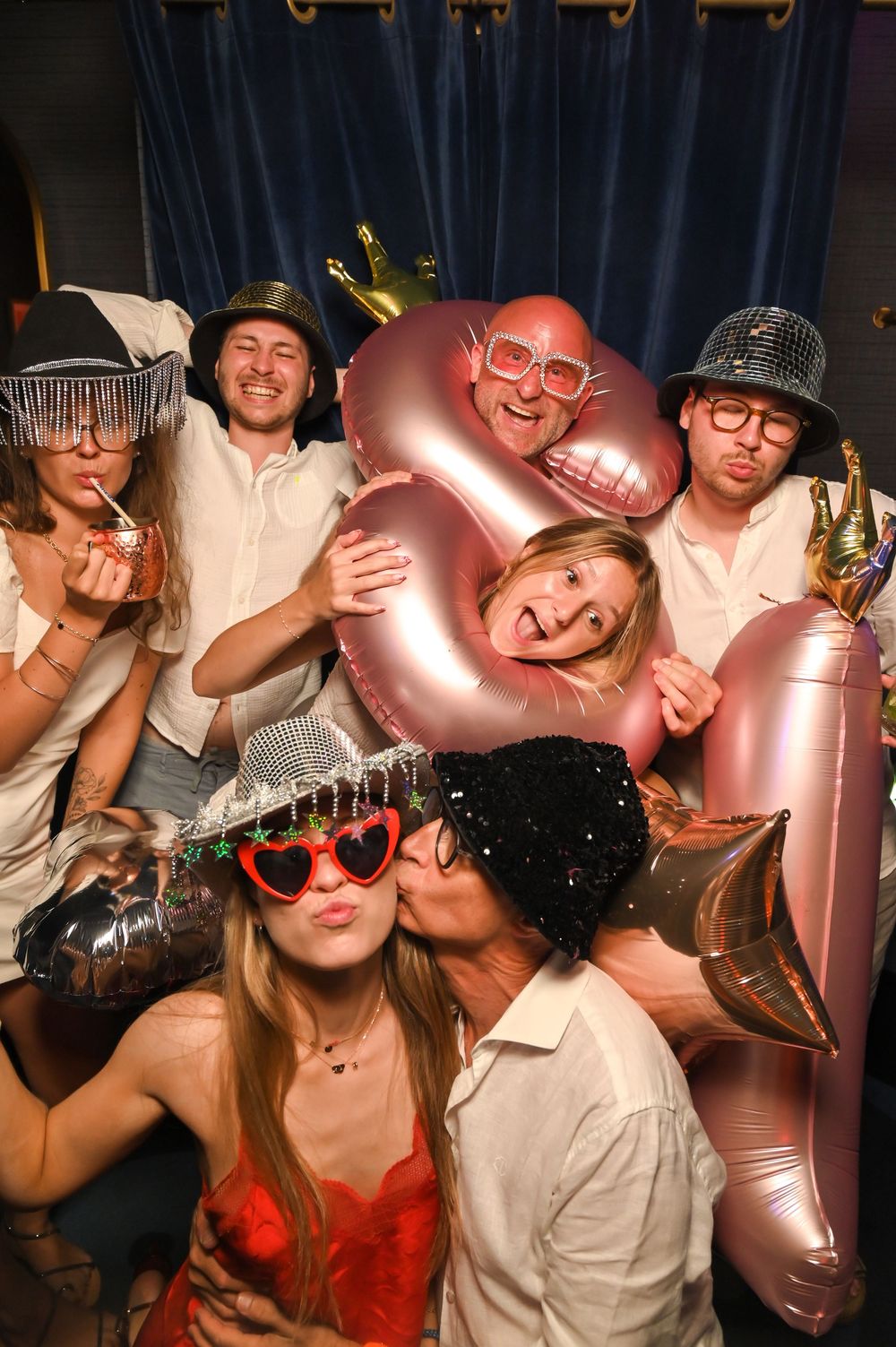 Guests posing in a retro photo booth at a luxury birthday celebration at Mongibello Ibiza.