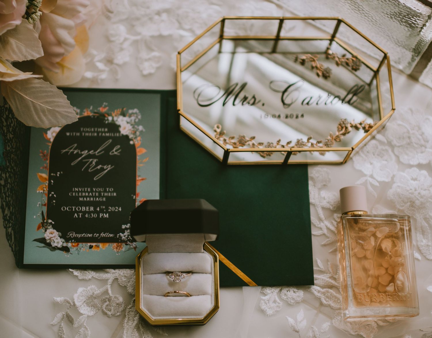 Wedding stationery flat lay featuring emerald green invitations and gold geometric details.