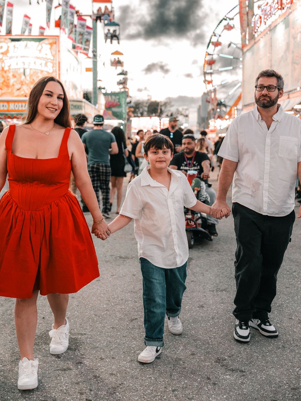 Group walking together at a carnival wearing coordinated red and white outfits.