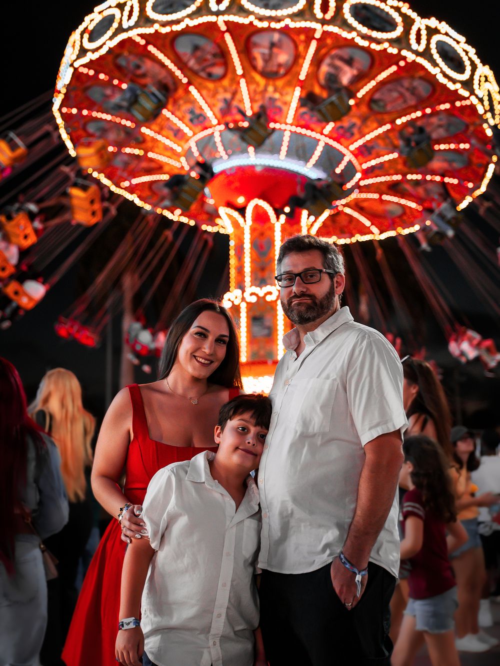Festive carnival scene with illuminated rides and people enjoying the atmosphere.