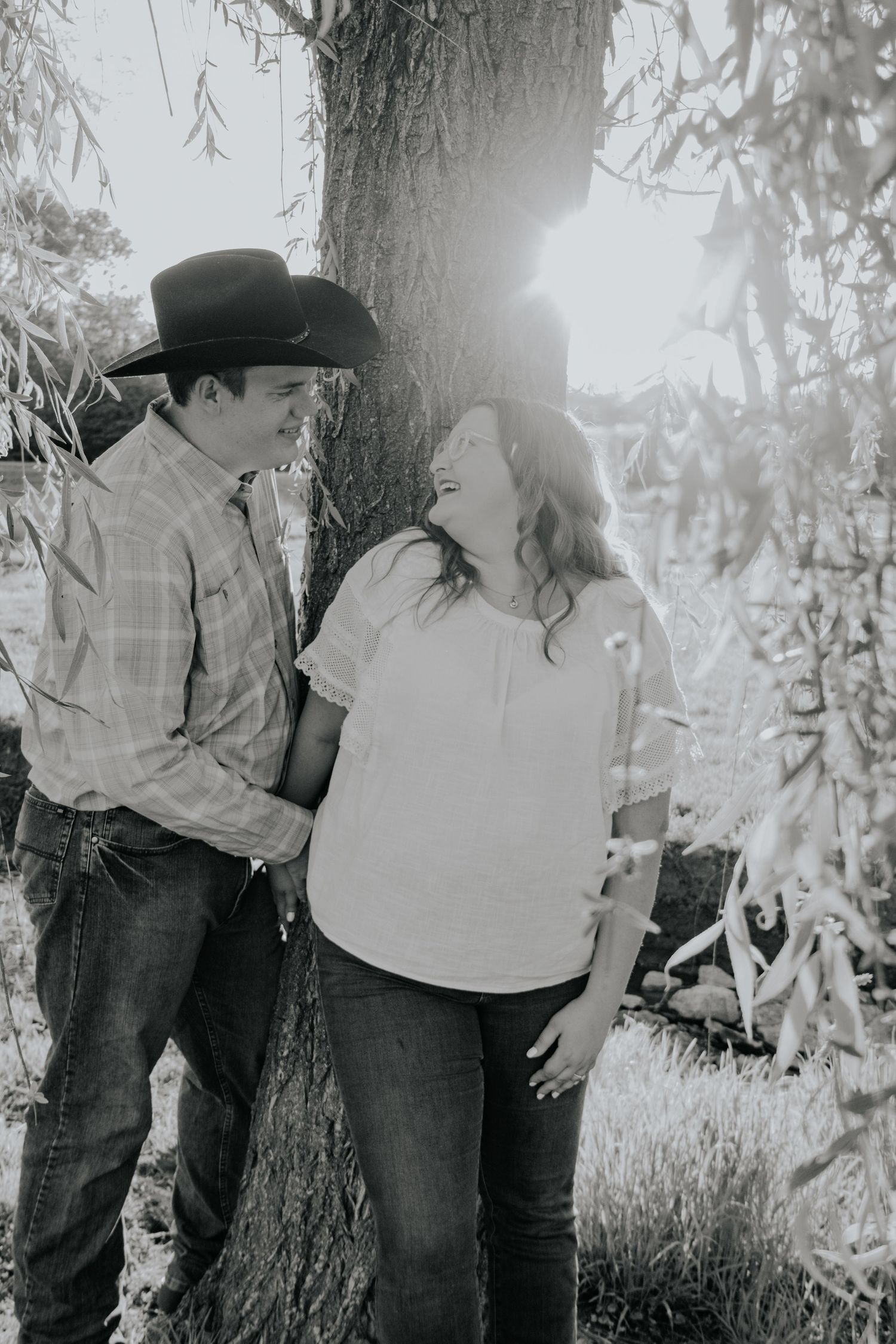 Black and white photo sequence showing a romantic couple embracing against a tree trunk in a rustic outdoor setting.