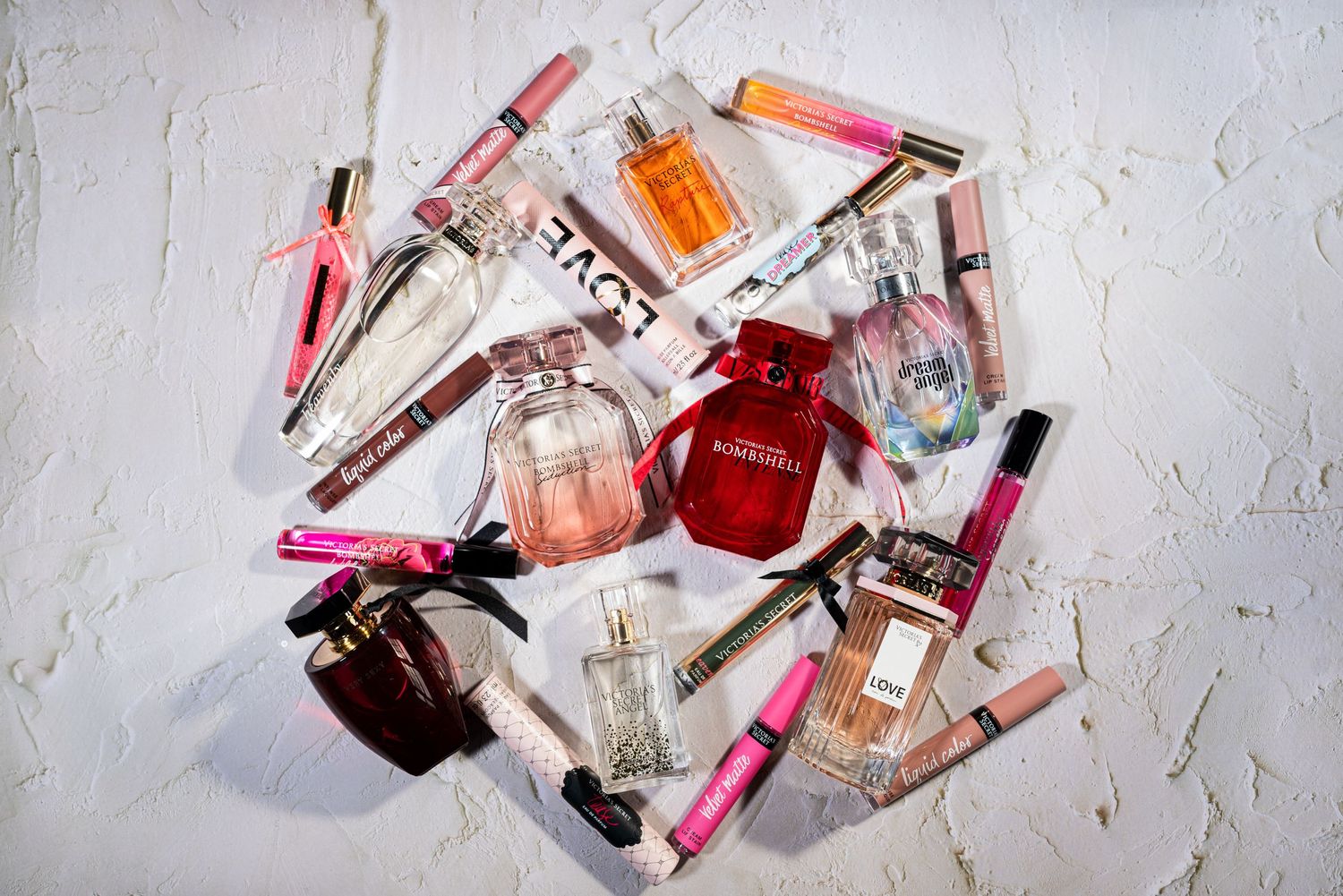 Product photo of Victoria Secret perfume bottles, perfume rollers, and lipsticks.