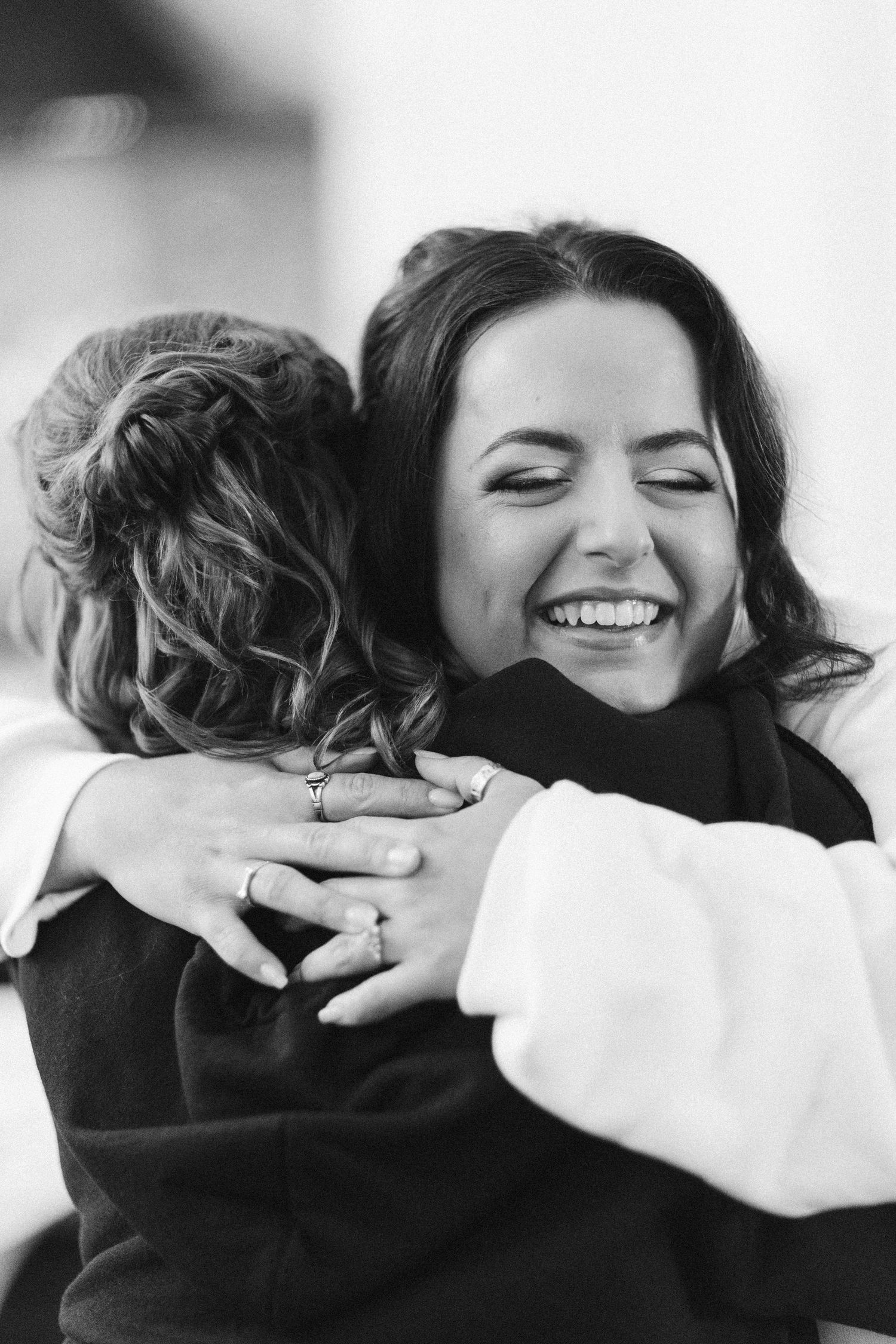 An emotional black and white photograph capturing a warm embrace between two people.