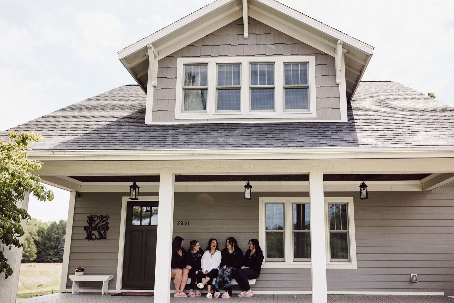 Exterior shots of a modern craftsman style house with light colored siding and white trim.