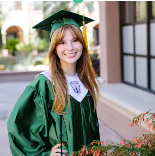 Smiling graduate wearing a green cap and gown