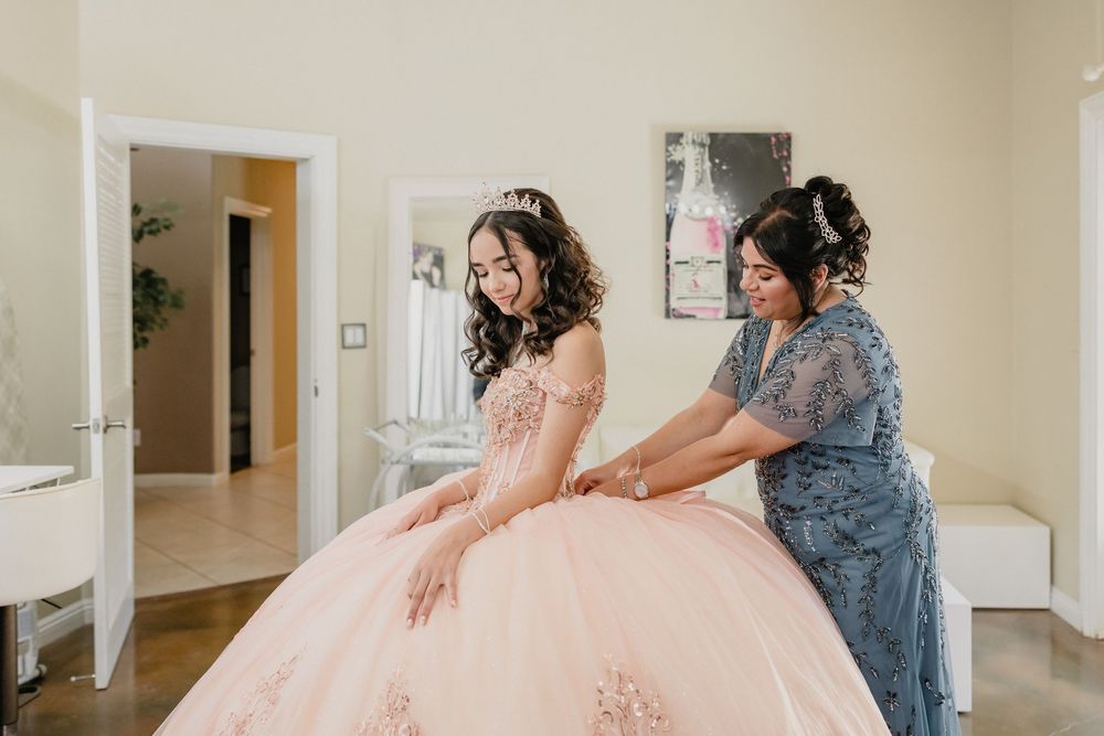 A dreamy shot of quinceanera getting ready with her mom before the quince festivities