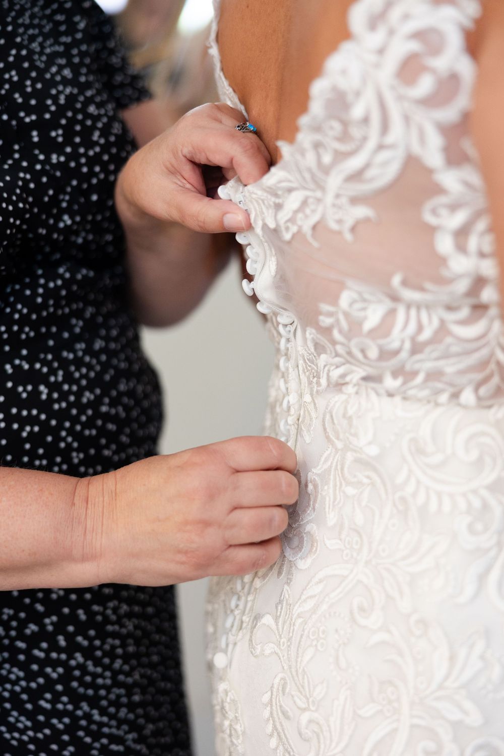 Close up detail shots of delicate lace beadwork on a white wedding gown.