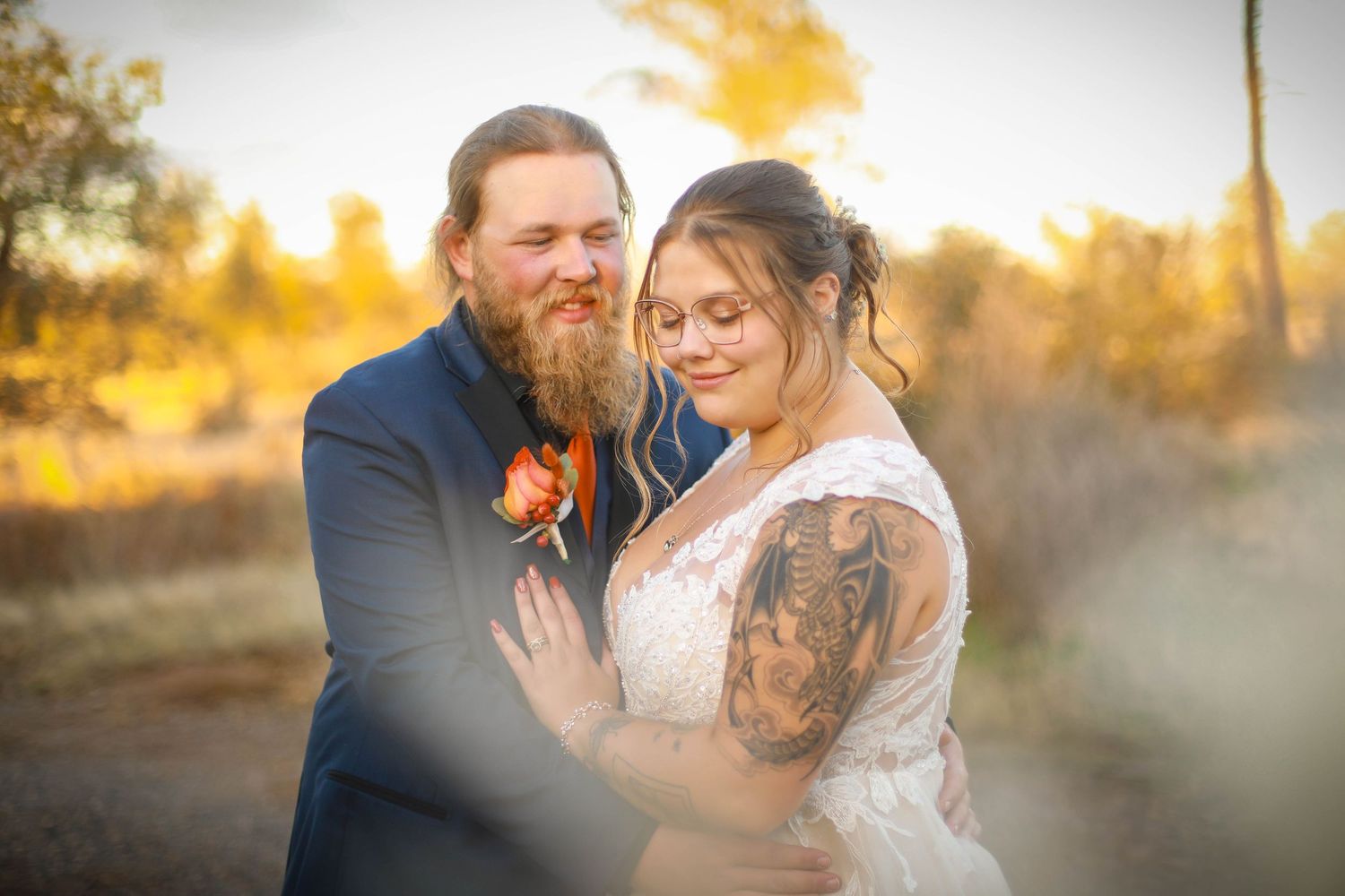 Intimate wedding portrait in golden sunset light with atmospheric fog effects.