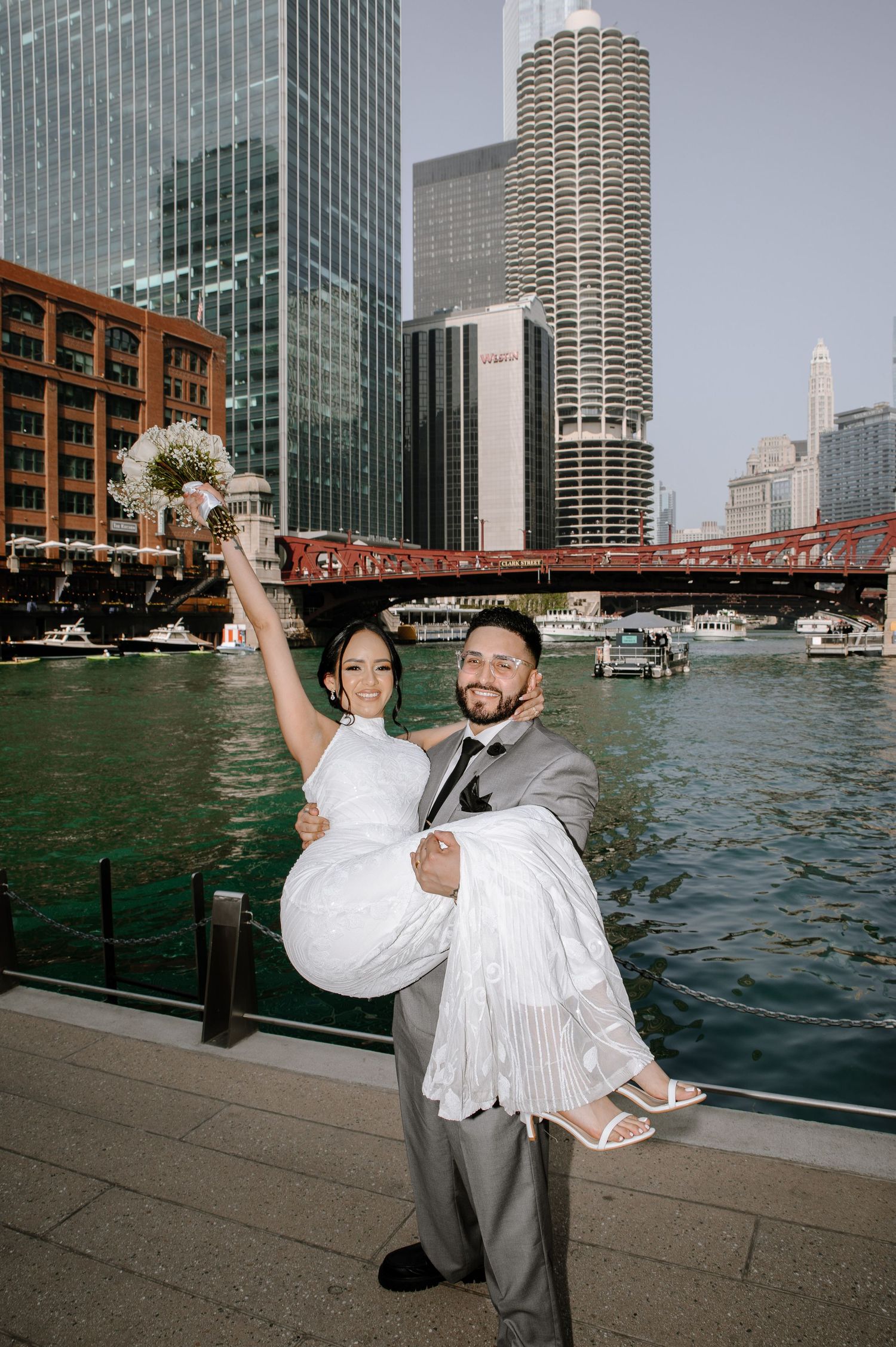 A sequence of a newlywed couple sharing a joyful moment along Chicago's riverwalk with city skyscrapers in the background.