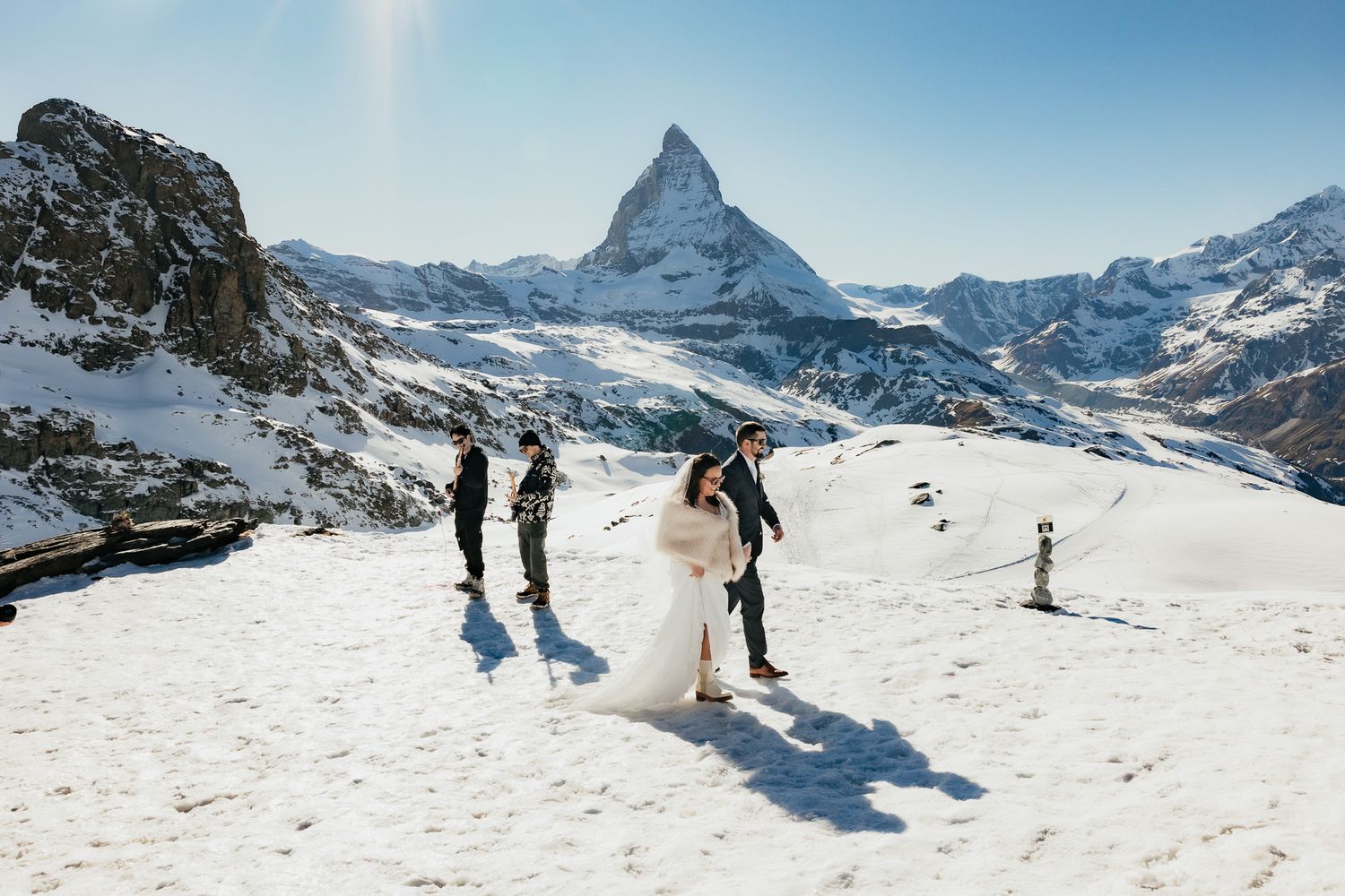 Winter wedding scene at Zermatt ski resort with the iconic Matterhorn peak in the background on a sunny day.