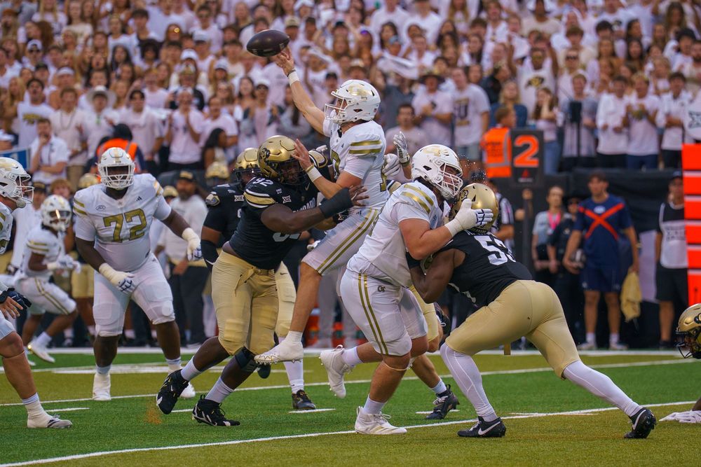 College football players engage in a line of scrimmage sequence during an intense game between Notre Dame and Navy.