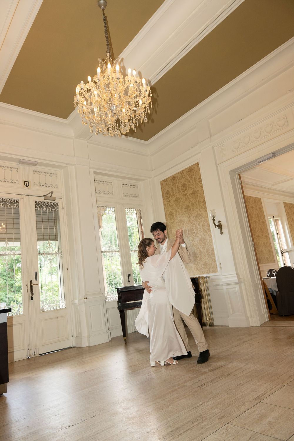 Series of dance movements in an elegant white ballroom with hardwood floors and crystal chandeliers.