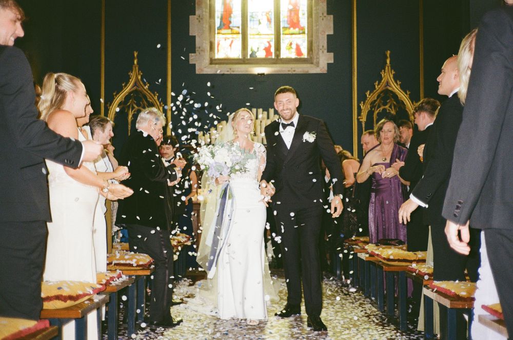 Wedding party celebrating with sparklers outside a church at night creating a magical illuminated atmosphere.