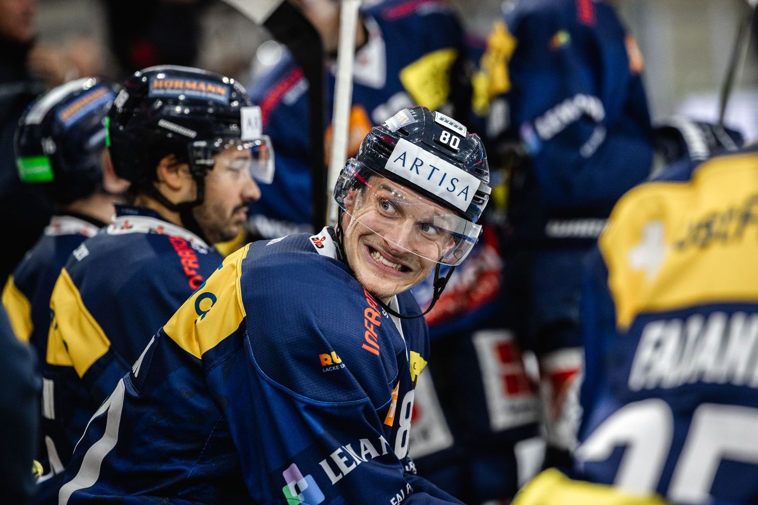Hockey players from opposing teams collide on the ice during an intense match-up.