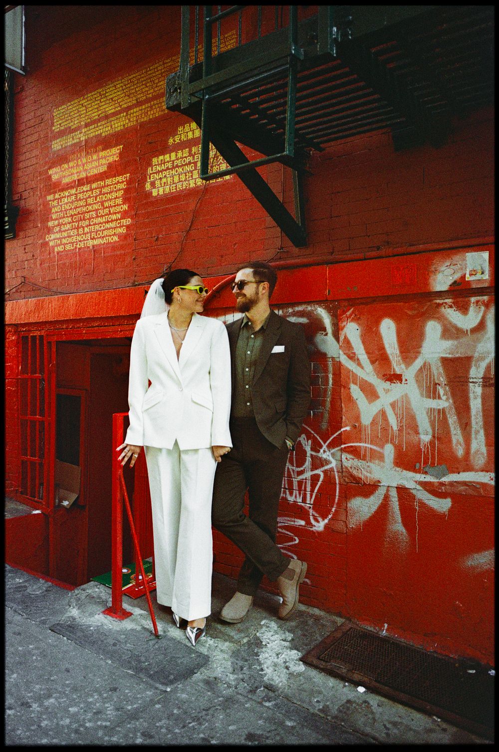 Series of candid shots against a vibrant red graffiti wall in an urban setting.
