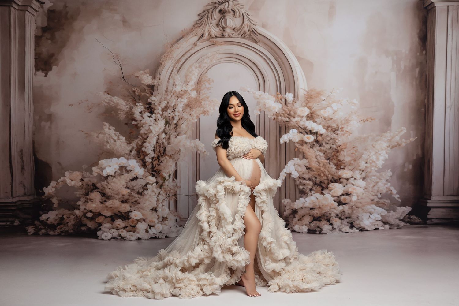 A dreamy floral maternity photo session featuring pink blossoms and a flowing peach tulle gown against a garden backdrop.
