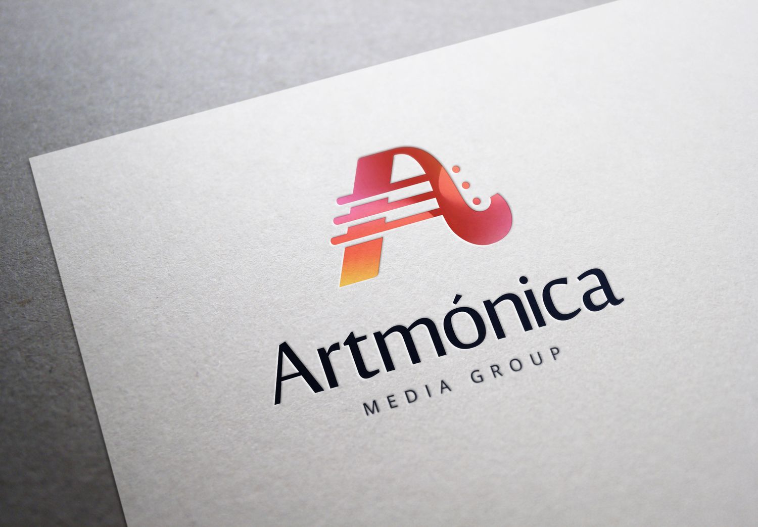 Red and pink circular logo design variations for Armonica Media Group shown at different angles on a gray background.