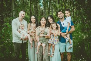 Extended family members gather for a group photo in a wooded natural setting. St Albert Family Photographer