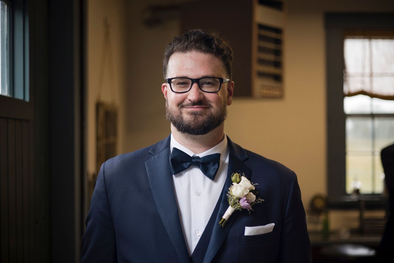 People in formal attire are decorated with small flower boutonnieres on their suit lapels at an event.