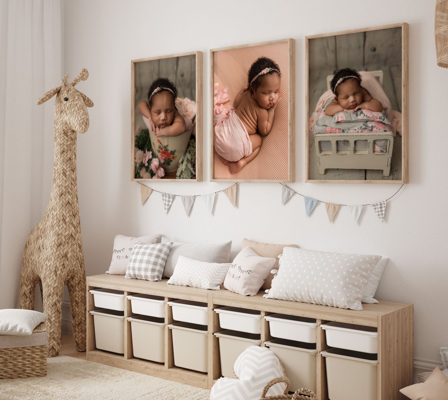 Nursery wall features three soft-toned portraits above a wooden storage bench with white baskets and plush pillows.