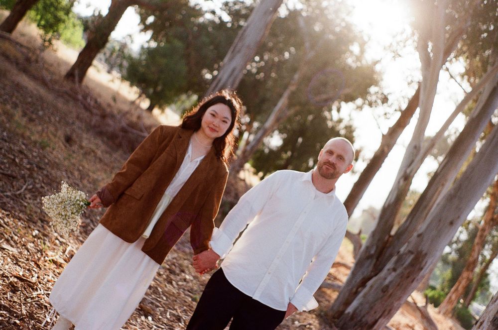 35mm film photo of couple with honey-hued light filtering through the trees in Ojai, California.
