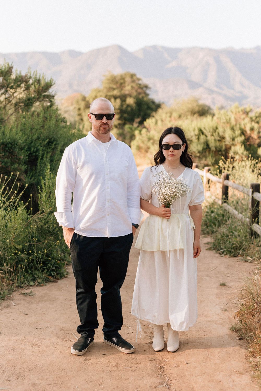 Moody Ojai film photographer shot of the couple with sunglasses against the distant Ojai hills.