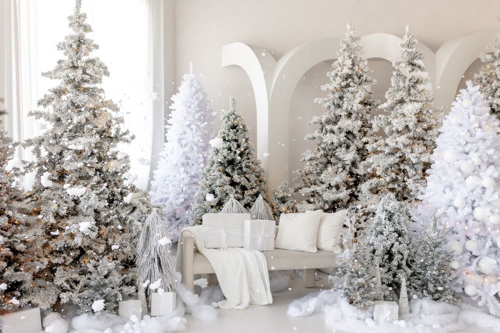 A row of flocked Christmas trees decorated in white and silver create an elegant winter wonderland display.