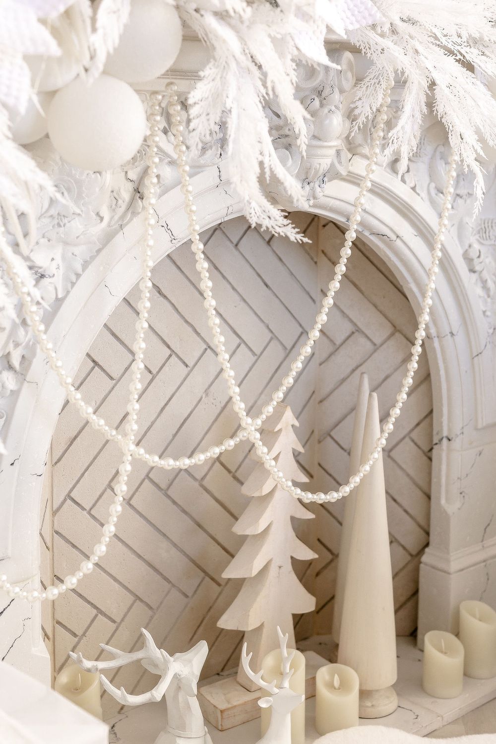 Close-up view of white paper Christmas trees and candles arranged on a herringbone pattern floor.