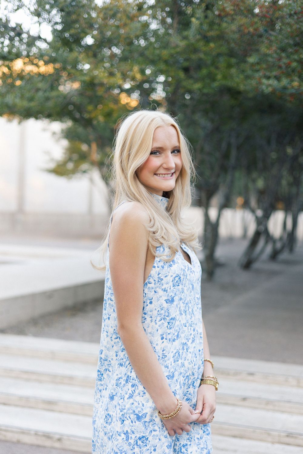 A series of photos showing someone wearing a blue and white floral sleeveless dress in an outdoor setting.