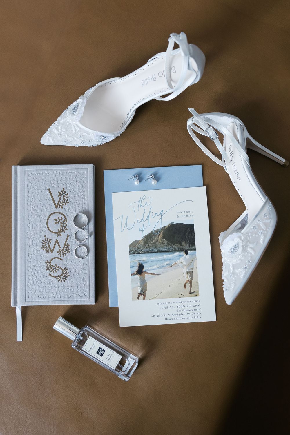 Wedding invitations laid out on a brown surface with matching envelopes and decorative embossing details.