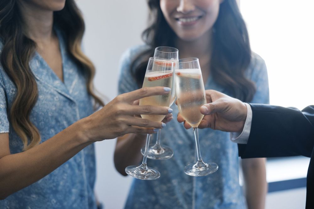Group of people toasting and celebrating with champagne glasses at an elegant event.